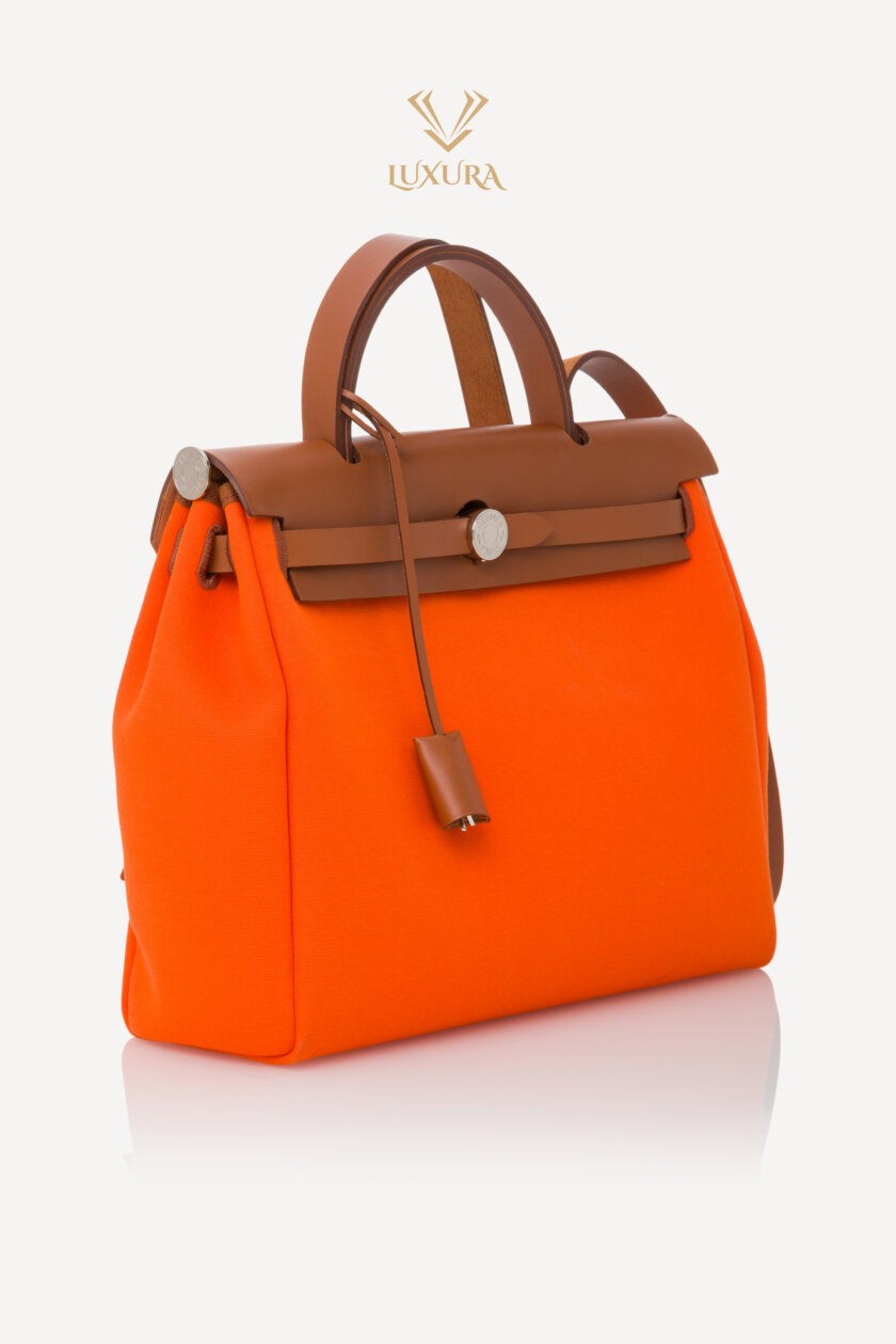 <span style="font-size: 10px; color: rgb(101, 101, 101);letter-spacing: .15em;">HARD TO FIND</span><br><strong>HERMES </strong><br><div style="margin-top:10px; font-size:16px;">Vache Hunter Toile Herbag Zip 31 PM Orange </div><br> - Image 3