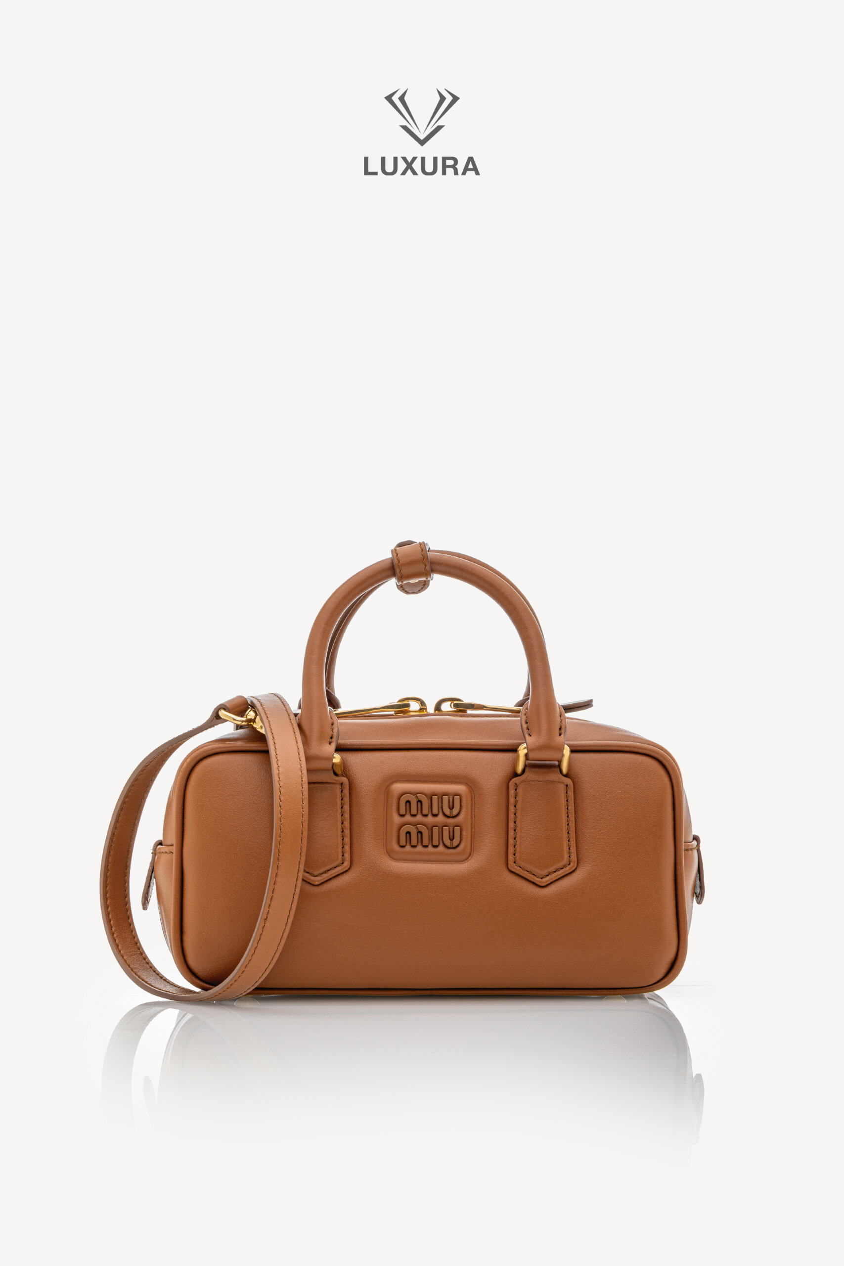<span style="font-size: 10px;letter-spacing: .15em">IN TRENDING</span><br>            <strong>MIU MIU</strong><br>            <div style="margin-top:10px;font-size:16px">Calfskin Small Arcadie Top Handle Cognac</div><br> - Image 6