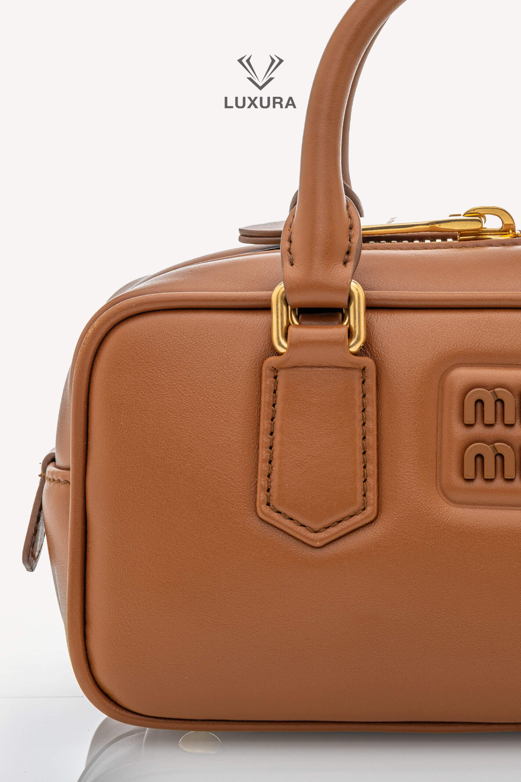 <span style="font-size: 10px;letter-spacing: .15em">IN TRENDING</span><br>            <strong>MIU MIU</strong><br>            <div style="margin-top:10px;font-size:16px">Calfskin Small Arcadie Top Handle Cognac</div><br> - Image 8