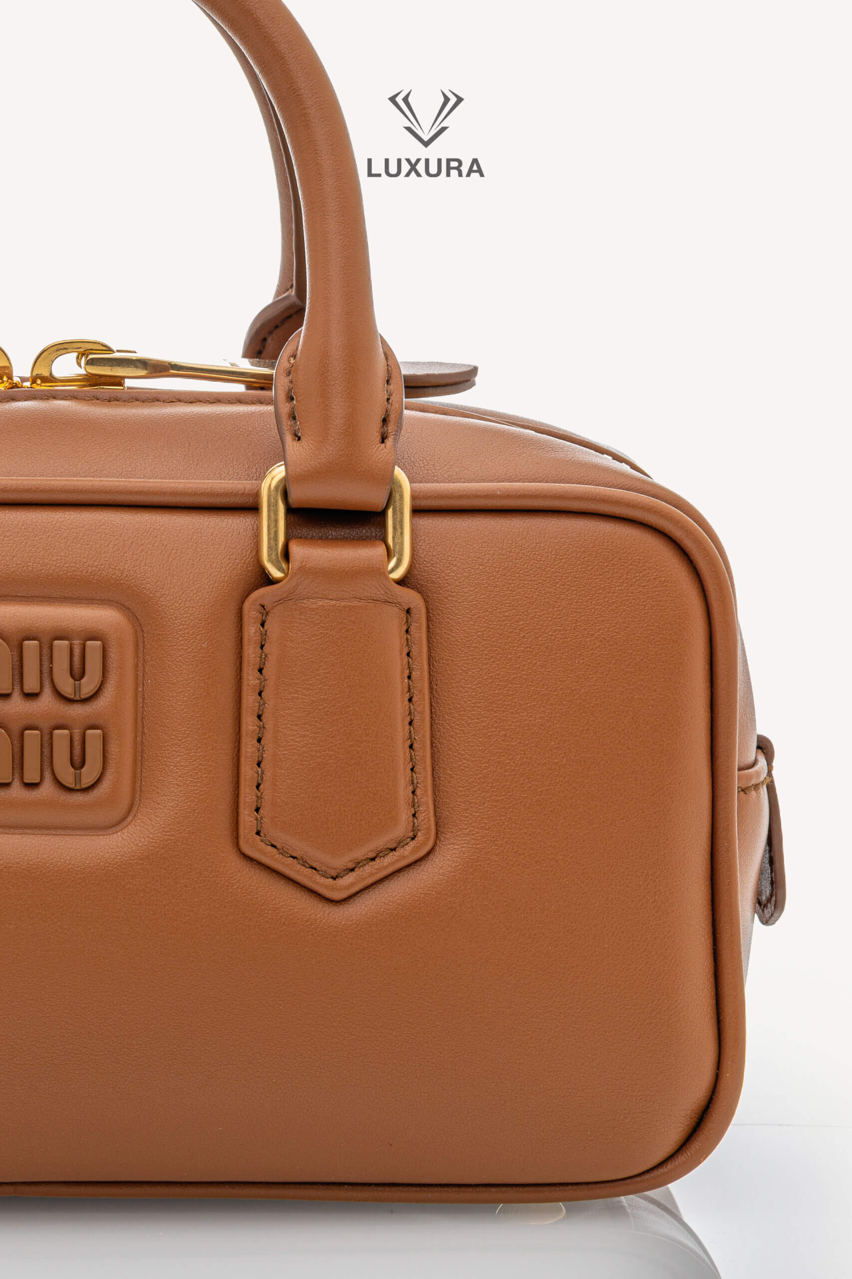 <span style="font-size: 10px;letter-spacing: .15em">IN TRENDING</span><br>            <strong>MIU MIU</strong><br>            <div style="margin-top:10px;font-size:16px">Calfskin Small Arcadie Top Handle Cognac</div><br> - Image 9